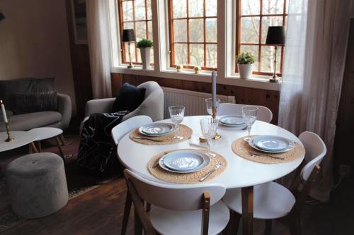 a white table with plates and glasses on it at Backens Fjällboende in Tännäs