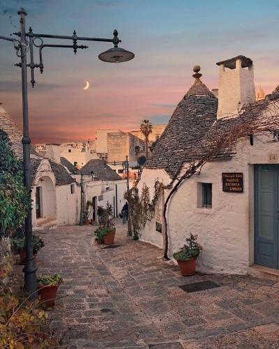 a group of white buildings with a sunset in the background at B&b SAN LORENZO in Conversano