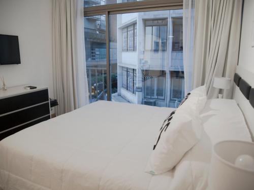 a bedroom with a white bed and a large window at Studio Esmeralda in Buenos Aires