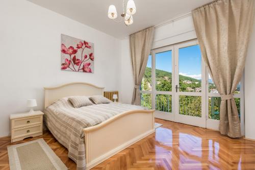 ein Schlafzimmer mit einem Bett und einem großen Fenster in der Unterkunft Family House Sara in Ičići