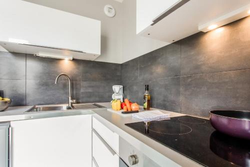 a kitchen with a sink and a bowl on the counter at 5ème Ciel - Première Conciergerie in Montpellier