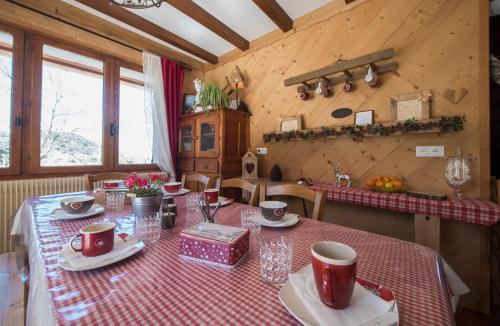 a dining room with a table with a red and white table cloth at B&B Chalet La Providence in Le Sauze