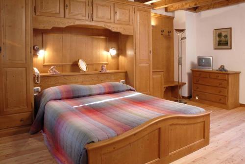 a bedroom with a large bed with a wooden headboard at Braidès in Buttrio