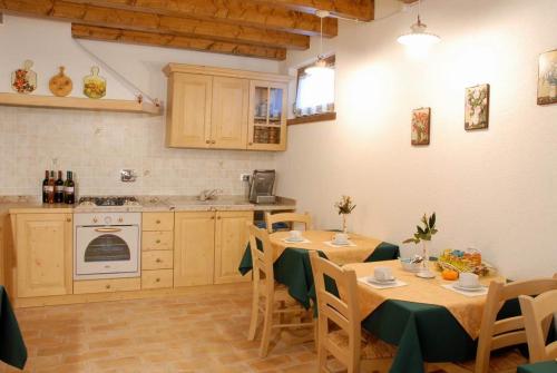 a kitchen with tables and chairs and a kitchen with a stove at Braidès in Buttrio