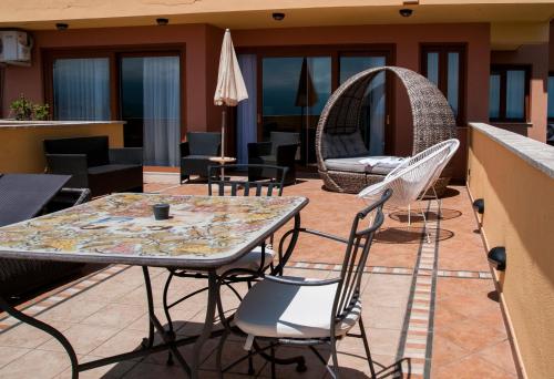 a patio with a table and chairs on a balcony at Villa Le Terrazze Charming Rooms in Taormina