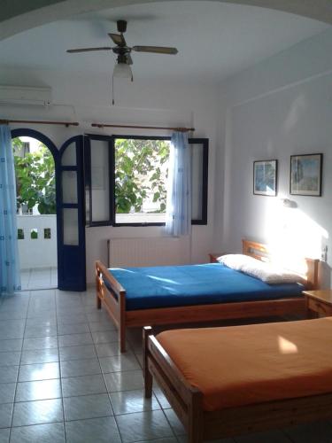 a bedroom with two beds and a window at Angelos Rooms in Myrtos