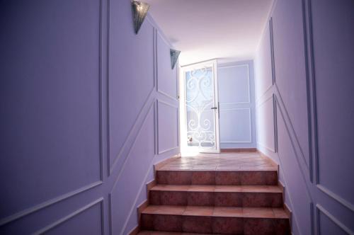 a hallway with a door and stairs with a window at Villa Le Terrazze Charming Rooms in Taormina
