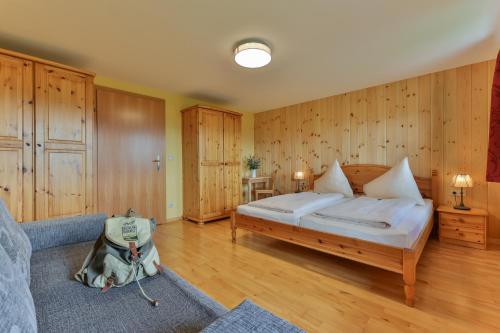 a large bedroom with a bed and a couch at Rutarhof in Rosegg