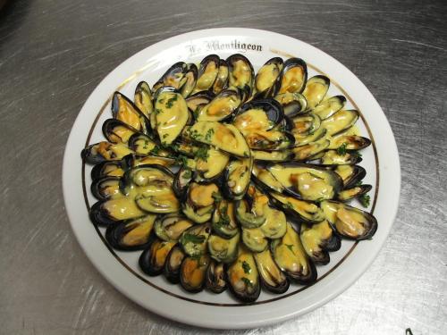 a plate of mussels and bananas on a table at Logis- Hôtel & Restaurant Le Montligeon in La Chapelle-Montligeon