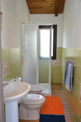 ein Badezimmer mit zwei Waschbecken, einem WC und einer Dusche in der Unterkunft Mongbeach in Acireale