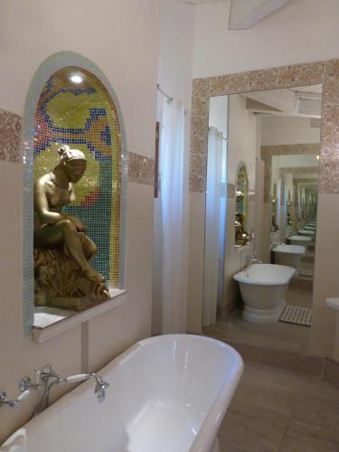 a bathroom with a tub and a sink and a mirror at Mas de la Chapelle in Arles