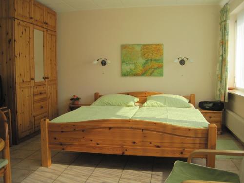 1 dormitorio con cama de madera en una habitación en Ferienwohnung Klanner, en Daisendorf