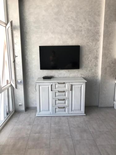 a white cabinet with a television on a wall at Грибовка Апартаменты 134 - 137 Black Sea Bugaz in Gribovka