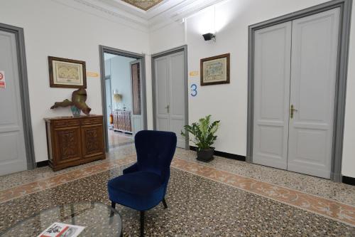 a room with a blue chair and a glass table at Check-Inn Rooms Genova Centro in Genova