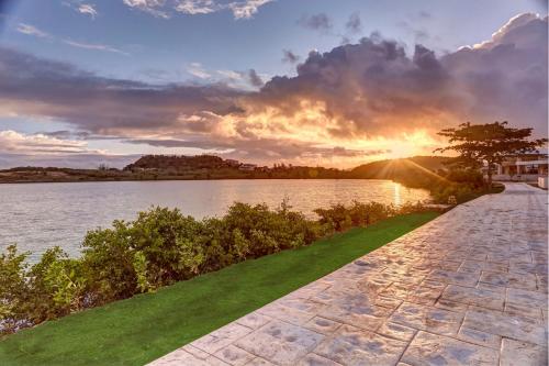 a pathway next to a body of water with the sunset at Royalton Antigua, An Autograph Collection All-Inclusive Resort in Five Islands Village