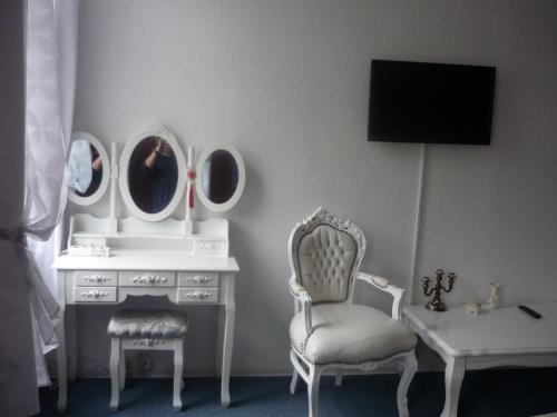a room with a dresser with mirrors and a chair at Hotel an der Fähre in Sankt Goar