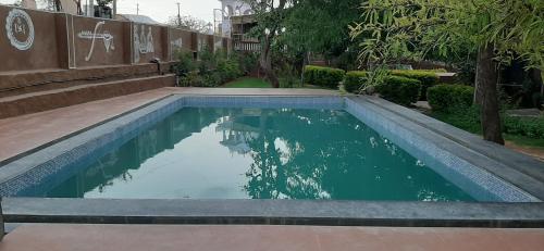 ein kleiner Pool in einem Garten mit Bäumen in der Unterkunft Pushkar Vela Resort in Pushkar