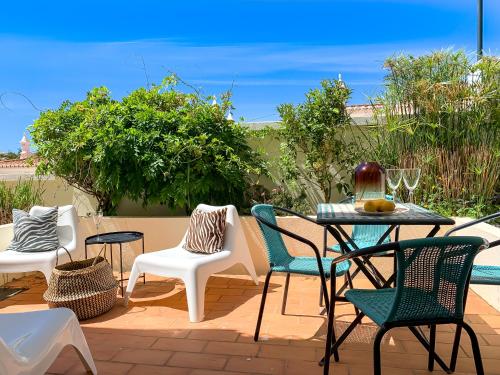 a patio with a table and chairs on a patio at 2BDR Townhouse Duplex with Pool by LovelyStay in Ferragudo