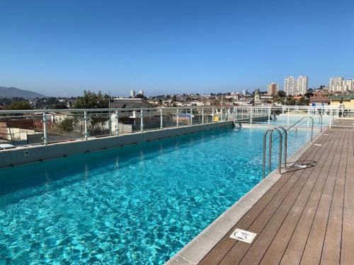 a large swimming pool with blue water on a deck at Nuevo, vista al mar Concon - Costa de Montemar in Concón