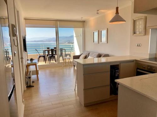 a kitchen and living room with a view of the ocean at Nuevo, vista al mar Concon - Costa de Montemar in Concón