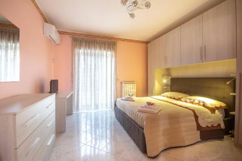 a bedroom with a large bed and a large window at Etna Sunshine in Linguaglossa