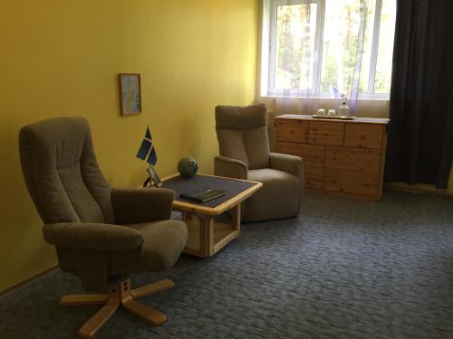 a living room with two chairs and a table at Torgu Royal Guesthouse in Iide