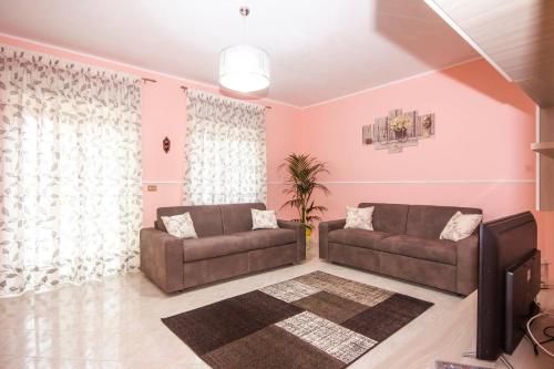 a living room with two couches and a tv at Etna Sunshine in Linguaglossa
