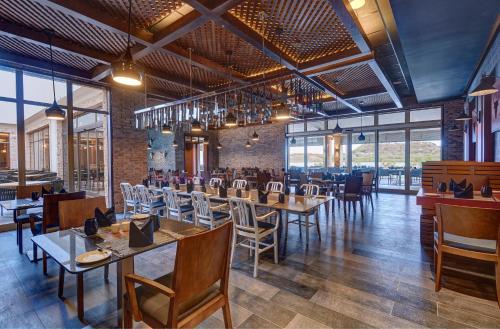 a restaurant with wooden tables and chairs and windows at Royalton Antigua, An Autograph Collection All-Inclusive Resort in Five Islands Village