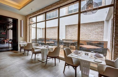 a restaurant with tables and chairs and a large window at Royalton Antigua, An Autograph Collection All-Inclusive Resort in Five Islands Village