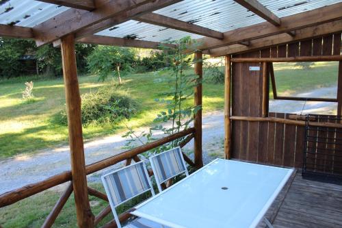 una mesa y dos sillas sentadas en un porche en Camping la Chevauchée, en Bussière-Dunoise