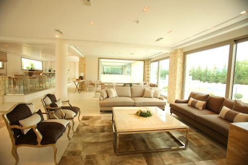 a living room with a couch and chairs and a table at Calma Hotel & Spa in Kastoria