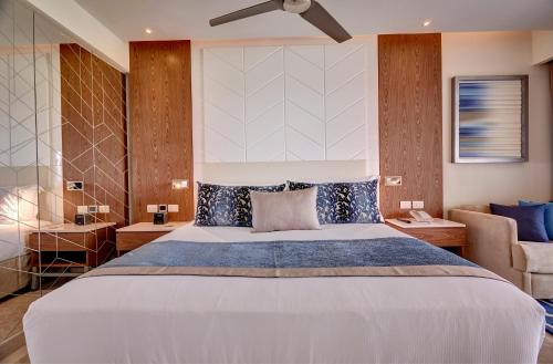 a bedroom with a large bed and a couch at Royalton Antigua, An Autograph Collection All-Inclusive Resort in Five Islands Village