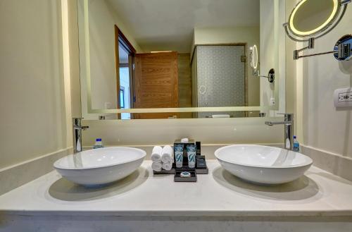 a bathroom with two sinks in front of a mirror at Royalton Antigua, An Autograph Collection All-Inclusive Resort in Five Islands Village