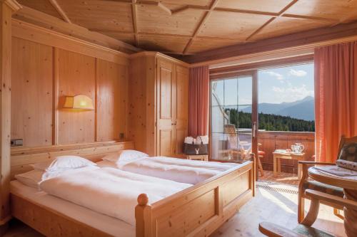 sypialnia z dwoma łóżkami i dużym oknem w obiekcie Hotel Lärchenhof Natur w mieście Seefeld in Tirol