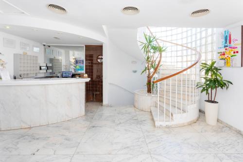 a lobby with a counter and potted plants at Hostal Molins Park in Ibiza Town