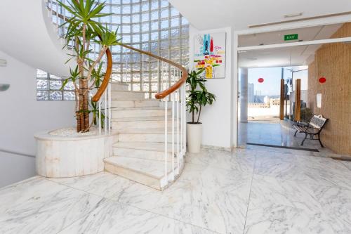 a lobby with stairs and potted plants at Hostal Molins Park in Ibiza Town