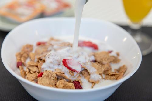 a bowl of cereal and fruit with a spoon in it at Hostal Molins Park in Ibiza Town
