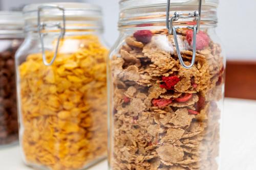 three glass jars filled with granola on a counter at Hostal Molins Park in Ibiza Town