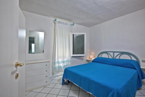 a bedroom with a blue bed and a window at Residence Stella Di Gallura in Porto Rotondo