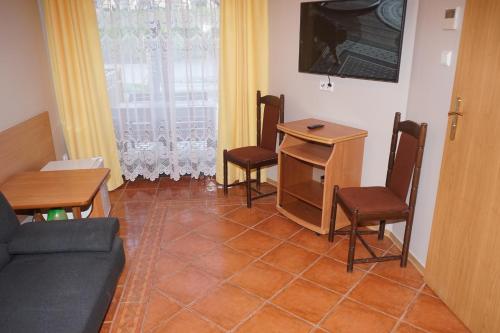 a living room with a couch and chairs and a table at Willa Joker in Krynica Morska