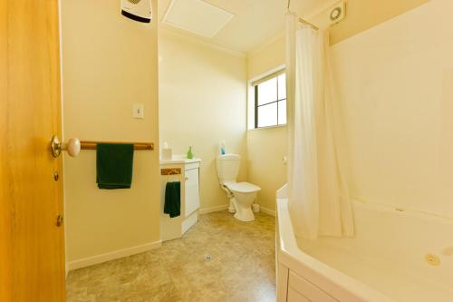 a bathroom with a toilet and a sink at Arrow Motel Apartments in Nelson