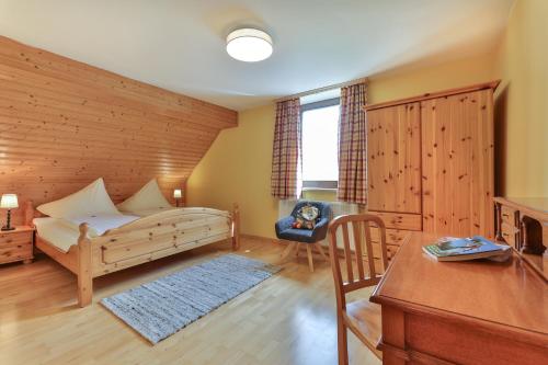 a bedroom with a bed and a desk and a chair at Rutarhof in Rosegg