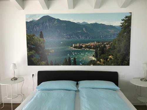 1 dormitorio con una gran pintura encima de una cama en Villa Cà bianca en Torri del Benaco