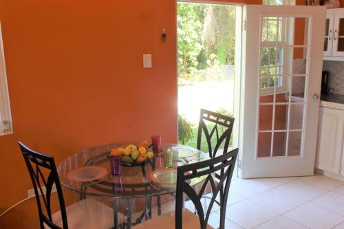 una mesa de cristal con un bol de fruta. en Tropical Apartments Tobago, en Scarborough