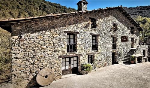 an old stone building with a mountain in the background at 4LLARS in Beget