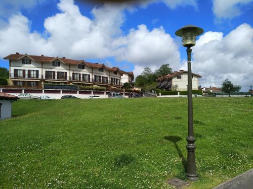 a street light in the grass in front of a building at Bordatxiki in Hondarribia
