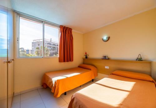 a room with two beds and a window at Rentalmar Los Peces in Salou