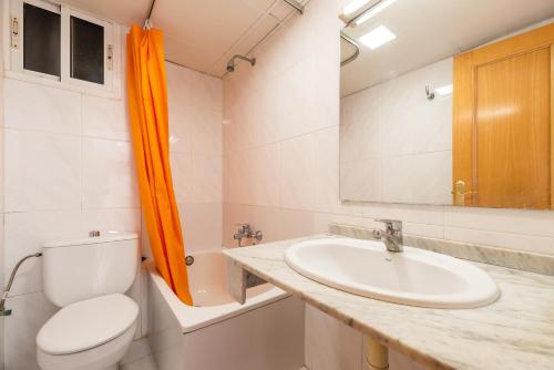 a bathroom with a sink and a toilet and a mirror at Rentalmar Los Peces in Salou