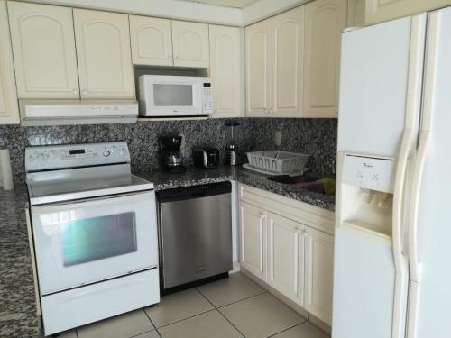 a kitchen with white appliances and white cabinets at Grand Marina Villas in Nuevo Vallarta