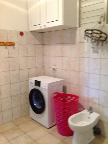 a bathroom with a washing machine and a toilet at Villa Café - Appartement F2 à Sainte-Anne in Sainte-Anne